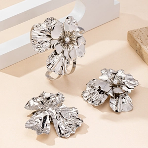Detailed close-up of floral jewelry set with silver wrinkled texture and pearls