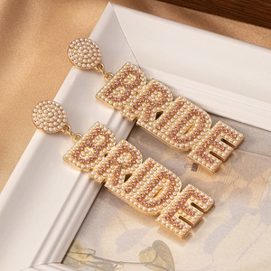 Detailansicht goldener BRIDE-Ohrringe mit weißen Perlen und rosa Strasssteinen