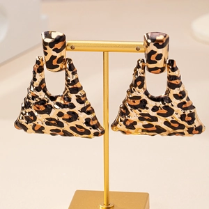 Macro view of leopard print triangle earrings with wavy edges on a gold stand