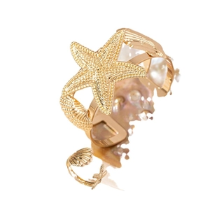 Set di gioielli dorati con stella marina e conchiglia, bracciale rigido e anello