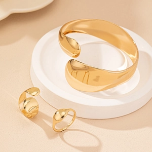 Set minimalista di bracciale e anello dorati con texture in metallo liquido