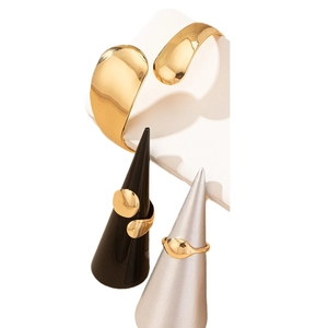 Set di gioielli in oro lucido con bracciale rigido regolabile e anelli geometrici