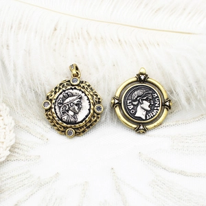 Detail view of retro coin pendants with portrait relief and vintage metallic finish