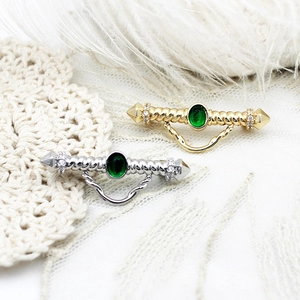 Elegant gold and silver brooches with green stones and hanging chains for dresses