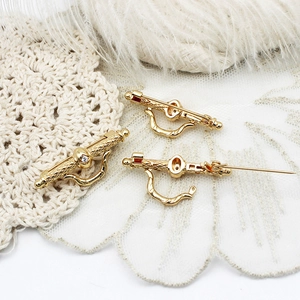 Elegant gold zircon brooch pin with a white crystal, showing front and back details