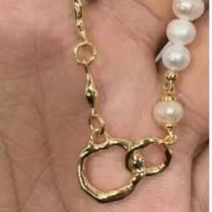 Collier baroque rétro français avec perles et maillons dorés présentés dans la main