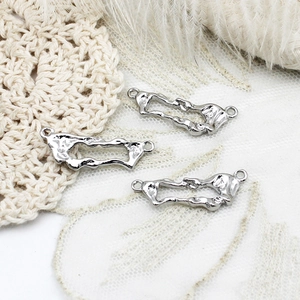 Close-up of silver irregular lava-style hollow charms for DIY jewelry making