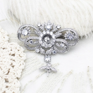 Detail of silver gourd brooch base with pavé zircons on elegant lace and feather