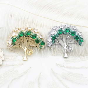 Elegant Tree of Life brooches in gold and silver with emerald green and white crystals