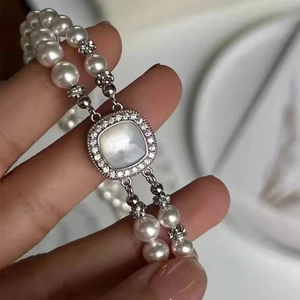 Detail view of double-strand pearl necklace clasp with square shell and micro-pave inlay