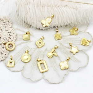 Macro detail of assorted gold geometric DIY pendants featuring CNC engraved metal patterns