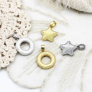 Detailed macro view of CNC cut star and ring charms with textured metal finish