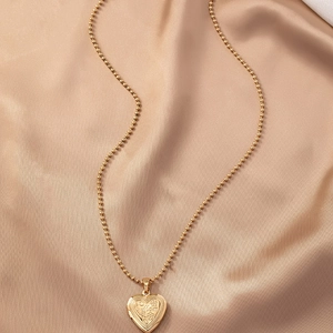 Vintage gouden hart medaillon ketting met Mom gravure op champagne zijden achtergrond