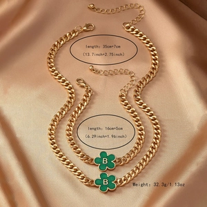 Golden curb chain jewelry set with green enamel flower and letter B pendant on silk