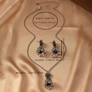 Close-up of vintage flower bell jewelry set with necklace and earrings on silk