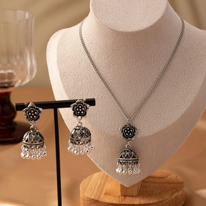 Detail of vintage silver Jhumka jewelry set with flower bell pendant and matching earrings
