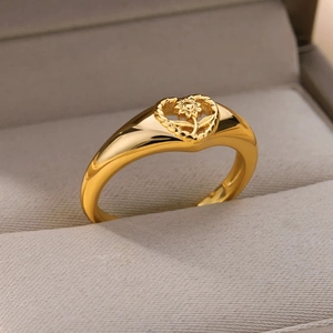 Close-up of gold-plated ring featuring hollow heart and sunflower motif detail