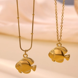 Detailed view of 18k gold tropical fish pendants on beaded snake and cable chains