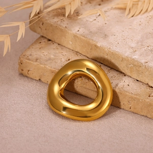 Macro shot of polished gold-plated sun brooch with an organic geometric texture