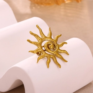 Vintage golden sunburst brooch with hammered metal texture on elegant white display