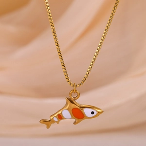 Detailed close-up of a golden fish pendant with orange enamel on a thin box chain