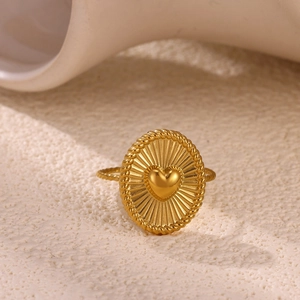 Macro-opname van een vergulde ovale ring met zonnestraalpatroon en hartvormig detail