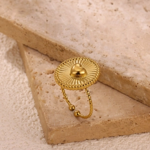 Macro-opname van vintage 18K vergulde hartring met zonnestraalpatroon en gevlochten textuur