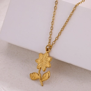 Detail of 18k gold plated stainless steel sunflower pendant on a geometric background