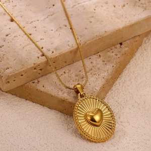 Detail van 18K vergulde ovale hanger met 3D-hart en zonnestraalmotief op een slangenketting