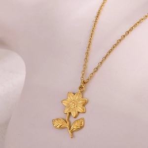 Detail of elegant 18k gold plated sunflower pendant with matte brushed finish and chain