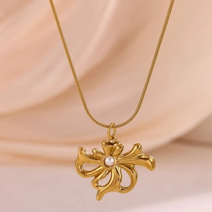 Close-up of golden irregular floral pendant with a central pearl on a snake chain