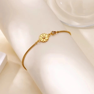 Vue détaillée du bracelet marguerite en acier inoxydable doré avec breloques zircon