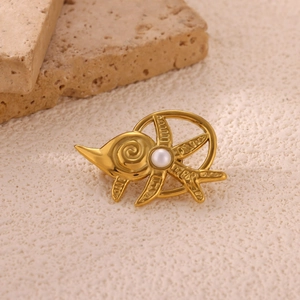 Macro detail of a gold sunburst fish brooch with a central pearl on a stone base