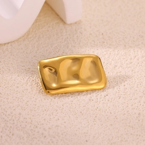 Macro shot of rectangular gold sun brooch with ripple texture and polished wavy surface