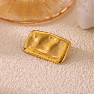 Detailed close-up of a gold rectangle brooch featuring a unique hammered wavy texture