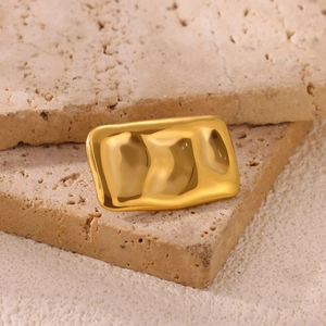 Detail view of rectangular gold-plated sun brooch with unique hammered ripple texture