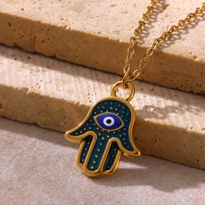 Detailed close-up of gold plated Hamsa Hand necklace with blue enamel Evil Eye pendant