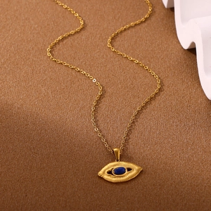 Detail of bohemian gold necklace featuring a blue evil eye pendant with starburst rays