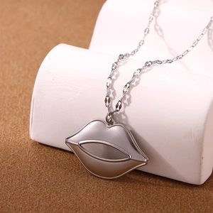 Detailopname van de zilveren lipvormige hanger aan een kruislingse ketting met glans