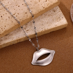 Detailopname van een gepolijste zilveren lippenhanger ketting op een luxe stenen display
