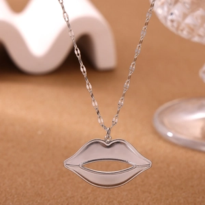 Gedetailleerde close-up van een zilverkleurige ketting met een holle rode lippen hanger