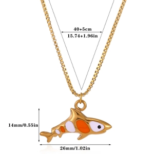Detail of shark pendant necklace in gold finish with orange and white enamel accents