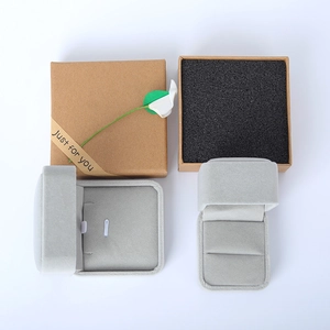 Détail de boîtes à bijoux en velours gris avec emballage cadeau en papier kraft et ruban