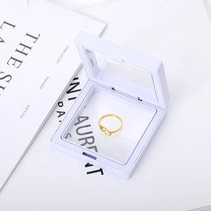 Bague double cœur dorée minimaliste présentée dans un écrin carré en film PE violet