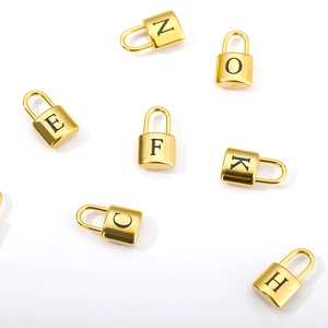 Detail of gold polished stainless steel padlock pendants with black engraved letters
