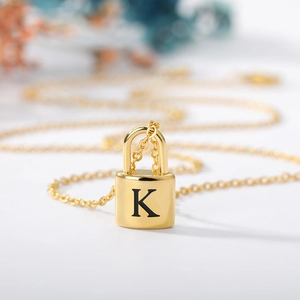 Detailed close-up of gold-plated padlock necklace with engraved letter K pendant