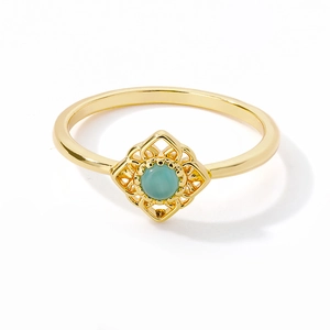 Detailed macro view of gold-plated ring with round pale blue opal and hollow floral setting