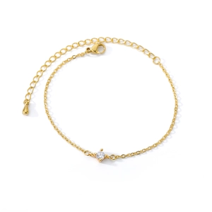 Detailed macro view of a 18k gold plated bracelet with a four-prong set sparkling crystal