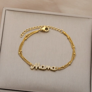 Detail view of 18k gold plated double layer bracelet with Mama plate and white crystals