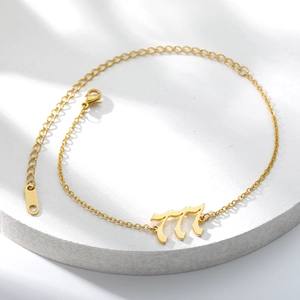 Detail of gold-plated stainless steel anklet with gothic 777 number pendant and lobster clasp